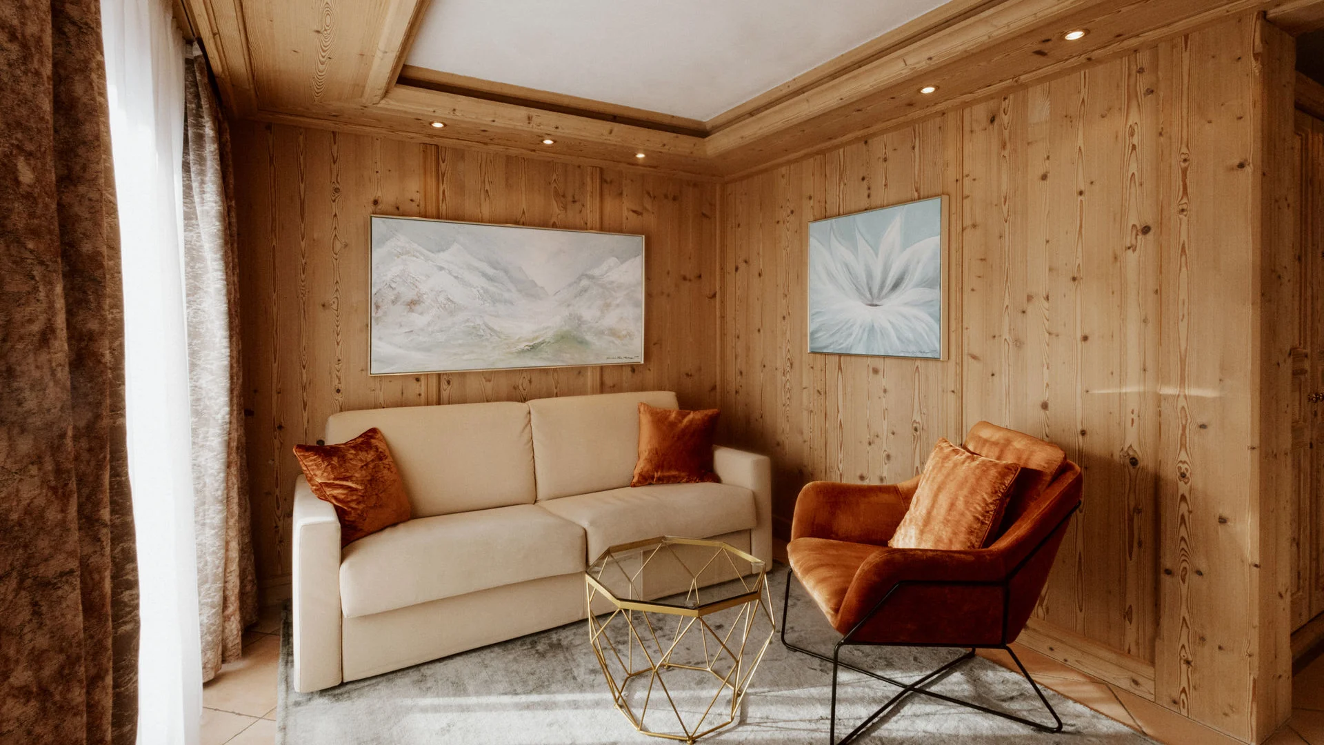 Cozy corner with sofa, armchair, and wooden walls in warm room