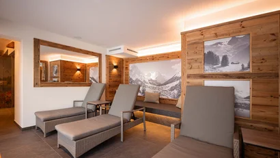 Gemütlicher Ruheraum mit Liegestühlen und Bergfotos an Holzwänden