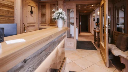 Wooden reception area with flower vases and open corridor in background