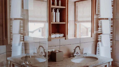 Holzbad mit Waschbecken, Spiegel und weißen Handtüchern an Heizkörper