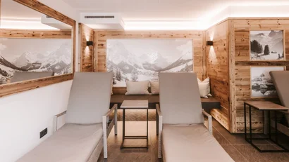 Relaxation room with wooden panels and lounge chairs in front of mountain panorama pictures