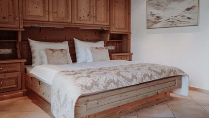 Gemütliches Schlafzimmer mit Holzmöbeln und dekorativer Bettwäsche