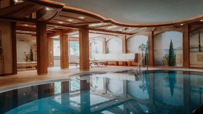 Hallenbad mit Holzsäulen, Liegen und Wandmalereien