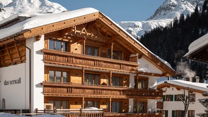 Holz Chalet im Schnee vor verschneiten Bergen und klarem Himmel