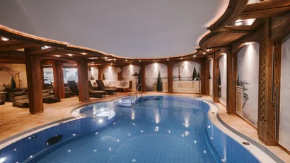 Interior of a spa area with illuminated pool and wooden ceiling