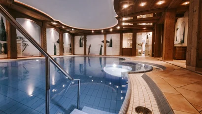 Indoor pool with wooden ceiling and wall murals in a serene setting