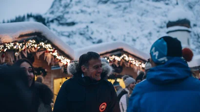 Menschen in Winterkleidung verkehren auf einem festlich beleuchteten Weihnachtsmarkt